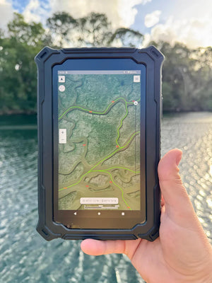 Hand holding the Hydros 7 rugged marine tablet at a dock, displaying SpotOn Fishing app’s fishing tracks and navigation routes for anglers.